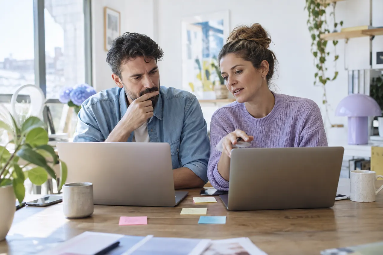 Two agency partners comparing platforms on laptops side by side